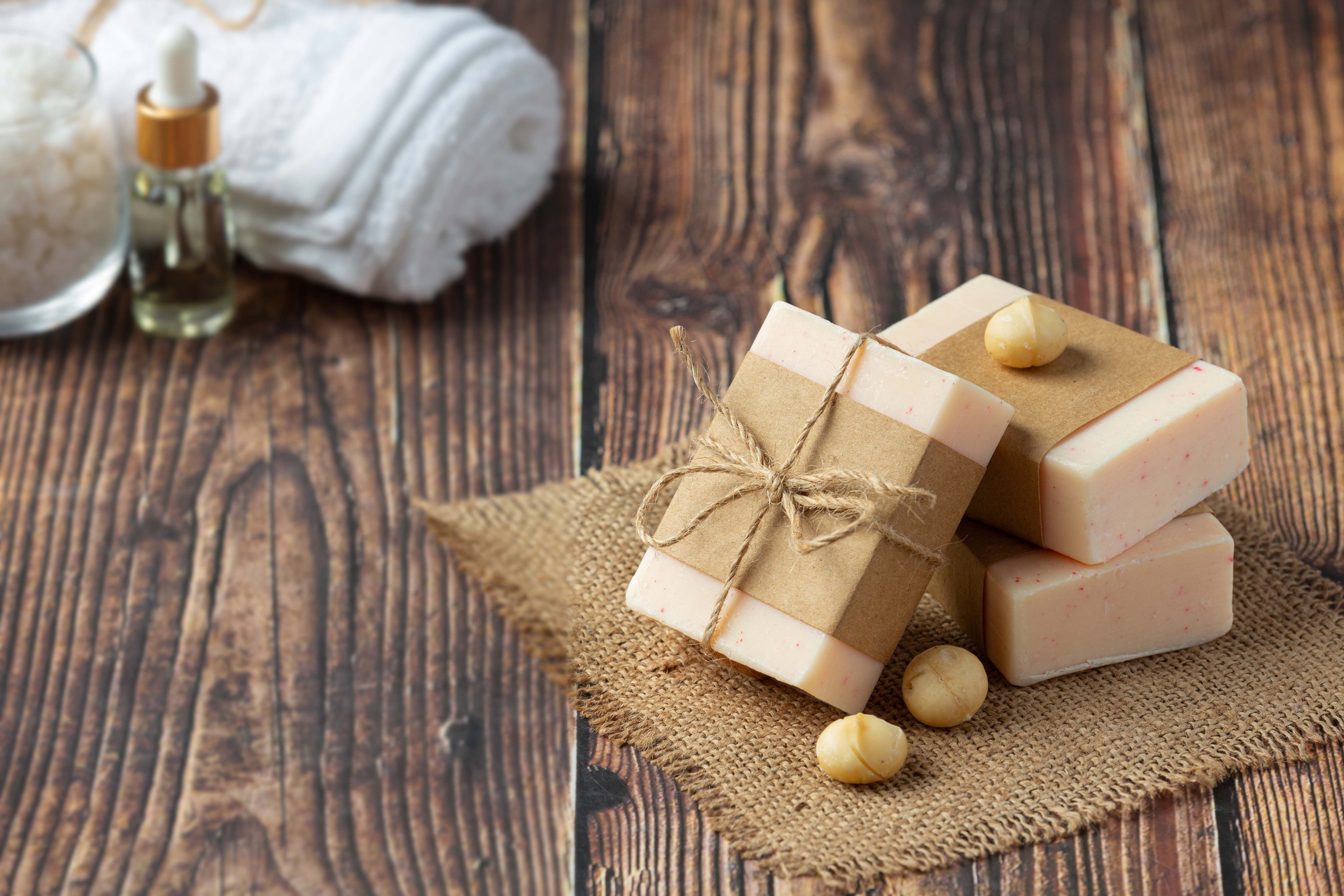 Three bars of soap on a wooden surface with a rustic background