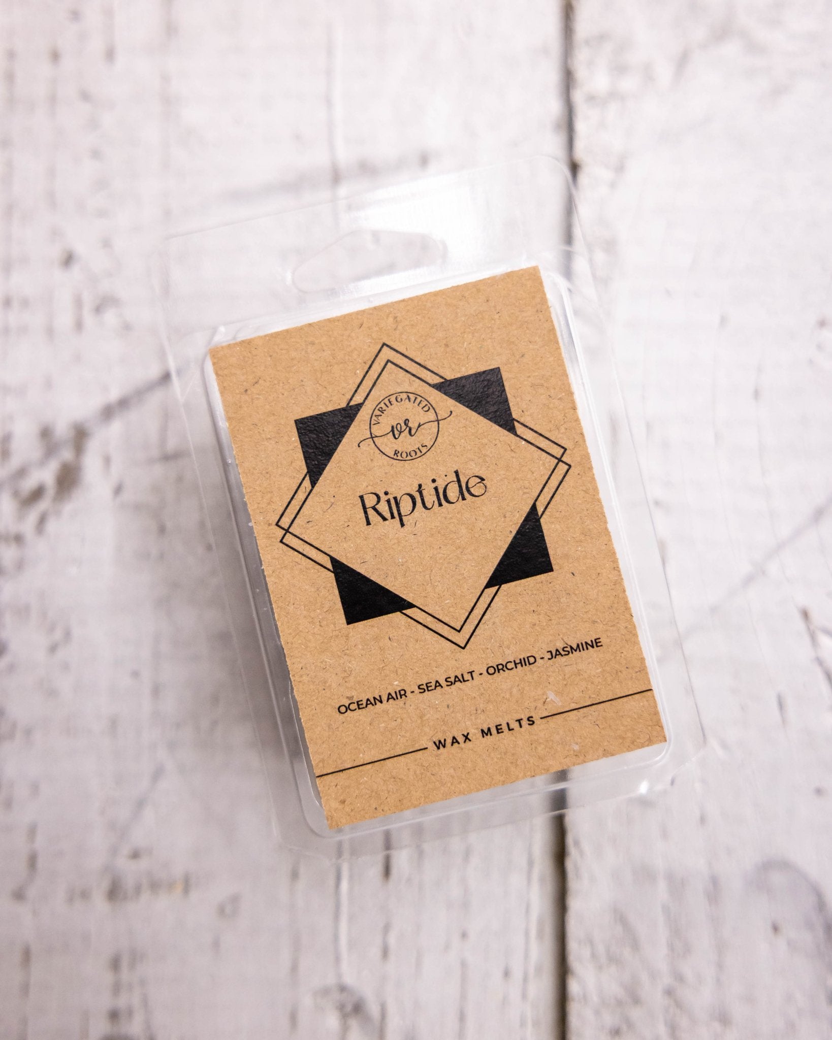 Pack of wax melts labeled 'Riptide' on a light wooden surface